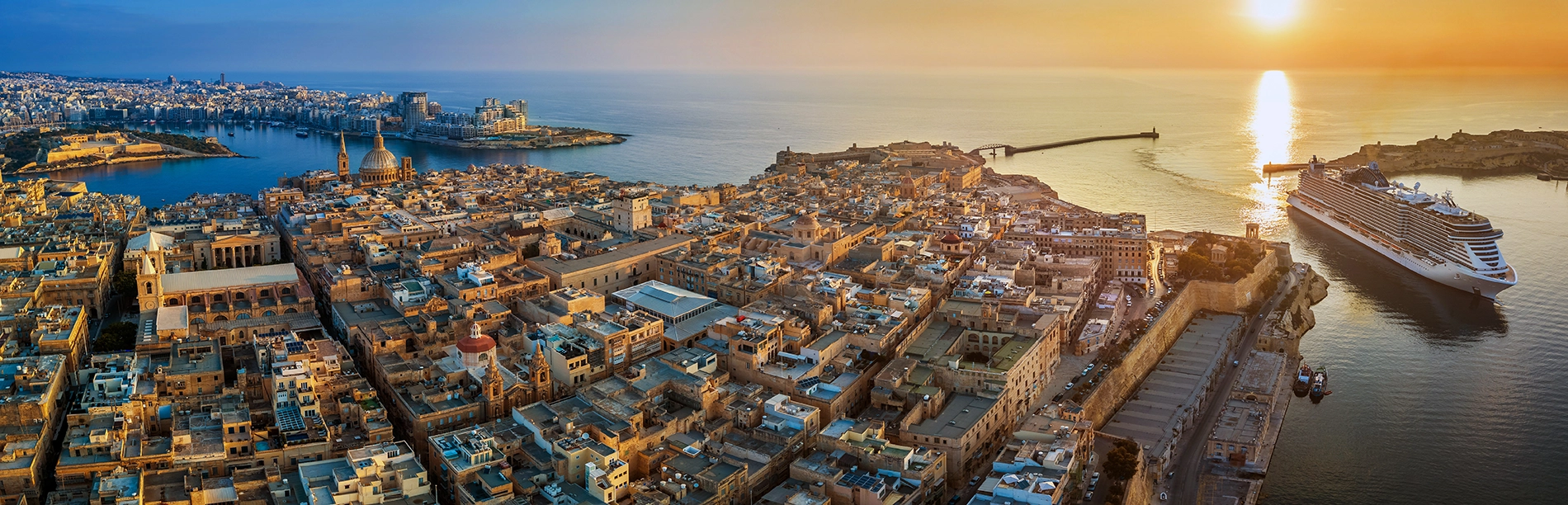 Aerial view of a coastal city skyline at sunrise